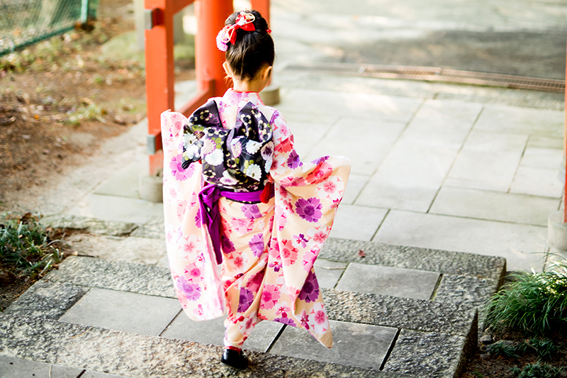 軽快に神社の階段を下りていく、着物を着た女の子の七五三写真