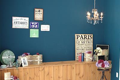 青緑の壁にレトロなポスターや雑貨を配した、温もりのある「Mai尾張旭」の立体スタジオ