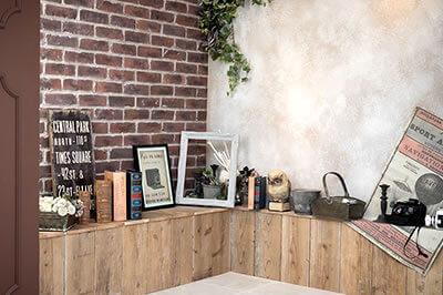 レンガと木材を組み合わせた壁面、アンティークの雑貨がちりばめられた立体スタジオ写真