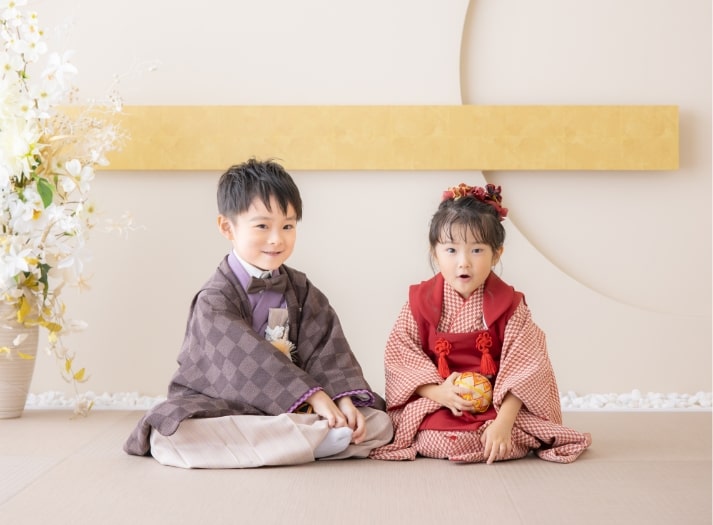 七五三の着物を着たご兄妹が、屋内で一緒に写真撮影している様子